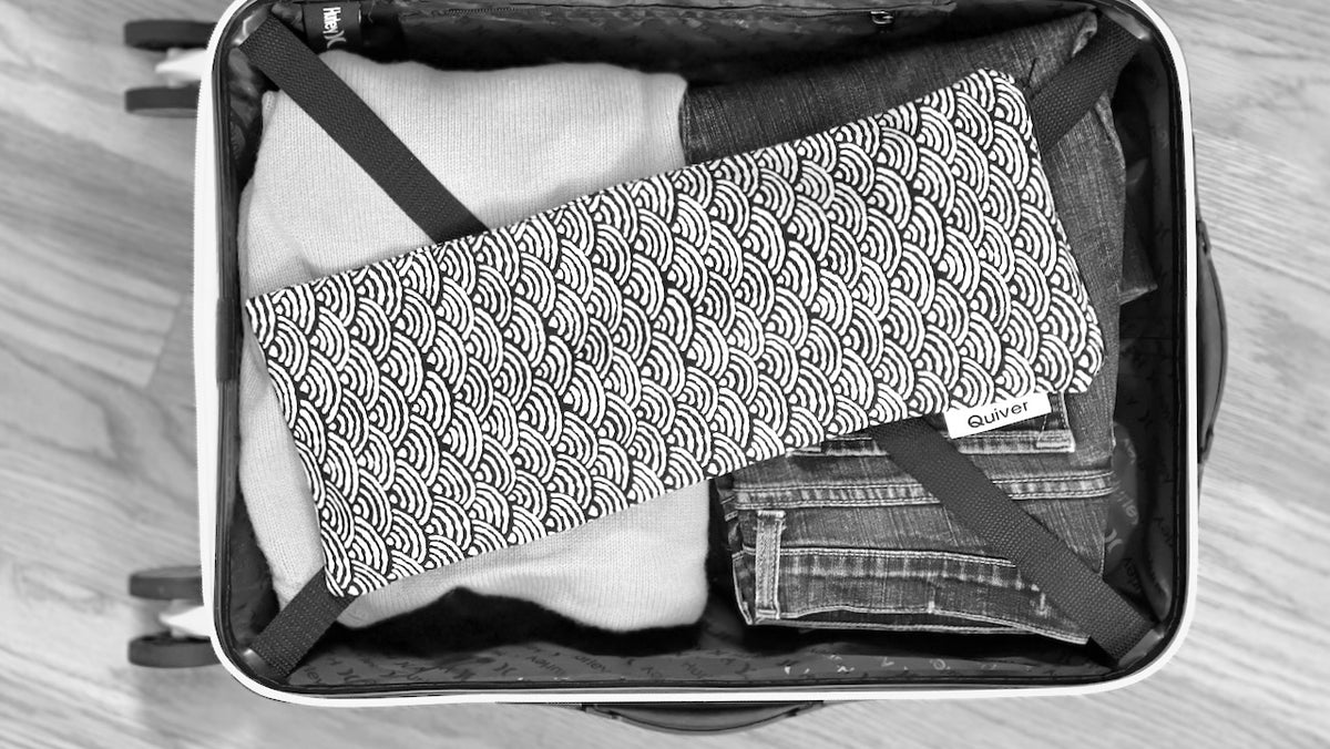 photo of quiver.love wand massager pouch in a suitcase illustrating discreet travel solutions. Product featured is in japanese fabric