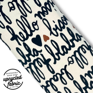 Close-up of French script and red glitter heart fabric on the Bisou Wand Pouch.
