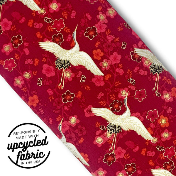 Detail of red and metallic gold Japanese fabric Quiver.love Original Magic Wand storage pouch featuring white cranes and cherry blossoms