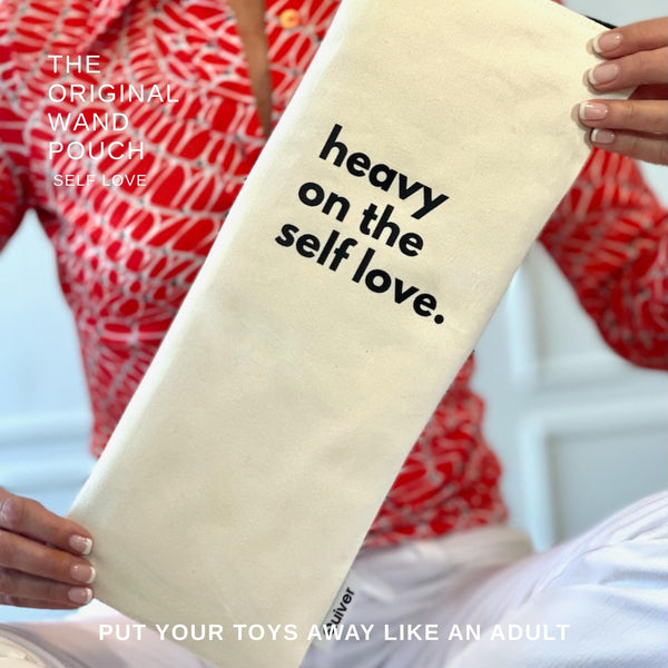 Quiver.love Original Wand zipper bag featuring text "Heavy on the Self love". Print is black on off white denim.  Held by model to illustrate size.